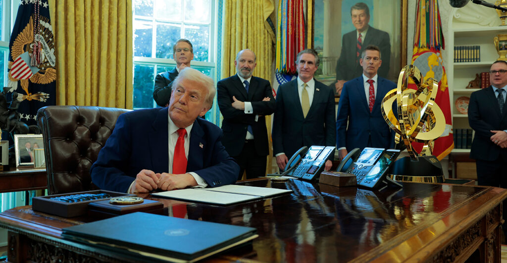 With Cabinet officials watching on, President Donald Trump signs an executive order in the Oval Office eliminating the regulations on shower heads.