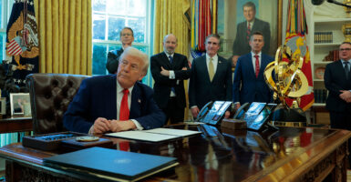 With Cabinet officials watching on, President Donald Trump signs an executive order in the Oval Office eliminating the regulations on shower heads.