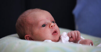 Beautiful three-week old baby in three-quarter profile.