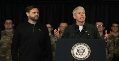 Vice President J.D. Vance in black sweater watches Energy Secretary Christopher Wright give remarks.
