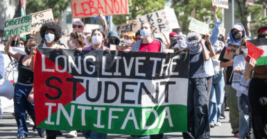 Anti-Israel protesters march behind "Long Live the Student Intifada" banner on 1st anniversary of October 7 massacre.