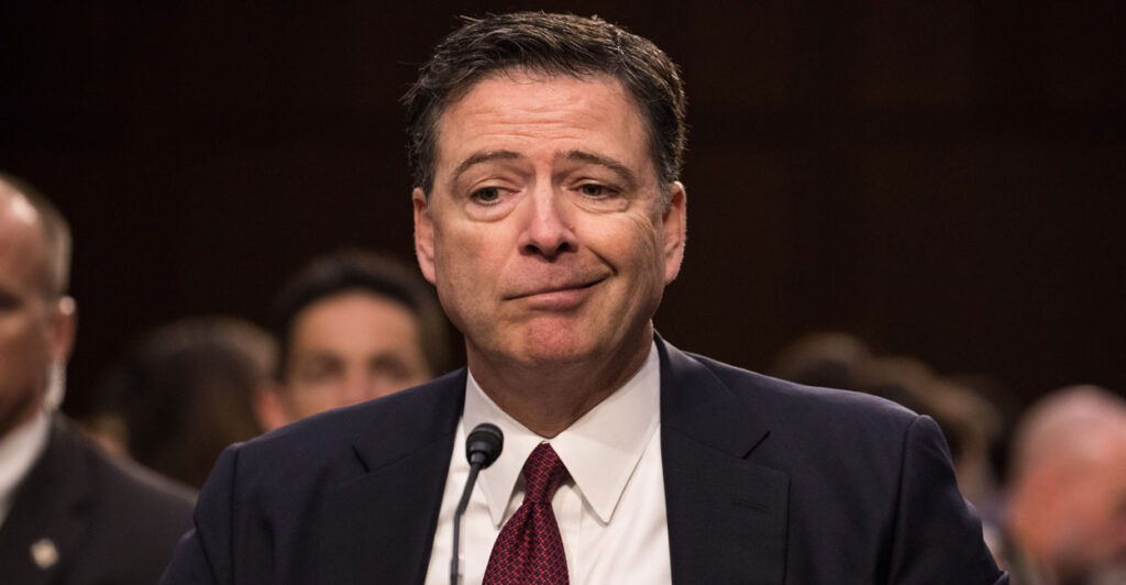 Former FBI Director James Comey offers a lopsided grin while testifying in front of the Senate Intelligence Committee in 2017.