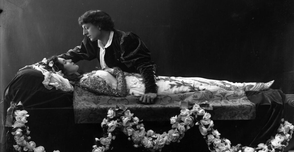 Black and white photo of Romeo grieving over Juliet from an 1895 production.