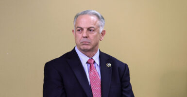 Then Clark County Sheriff Joe Lombardo looks to his left against a tan backdrop.