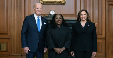 A robed Justice Ketanji Brown Jackson flanked by President Biden and Vice President Harris.