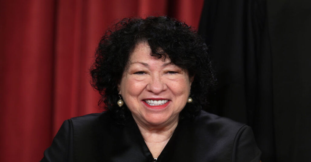 A smiling Justice Sonia Sotomayor in judicial robes with a black background.