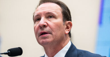 Louisiana Gov. Jeff Landry speaking into a microphone