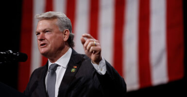 With a U.S. flag as backdrop, Rep. Mike Collins, R-Ga., speaks at the Cobb Energy Performing Arts Centre on Oct. 15 in Atlanta, Georgia.
