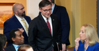 Speaker of the House Mike Johnson, R-La. (center), talks to seated Reps. Joe Neguse, D-Colo., and Mary Gay Scanlon, D-Pa., during a House Rules Committee meeting on Wednesday.