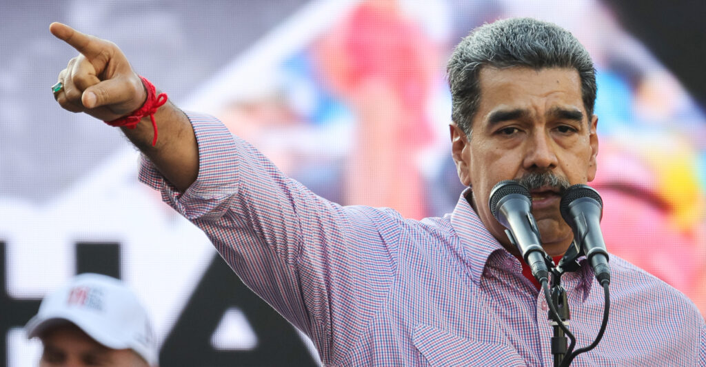 Nicolas Maduro delivering a speech, pointing to his right.