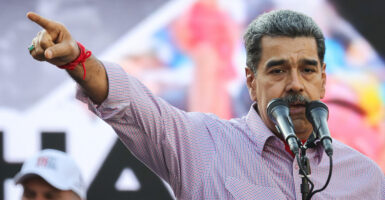 Nicolas Maduro delivering a speech, pointing to his right.