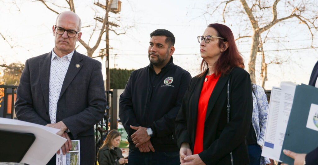 Hugo Soto-Martinez stands at a press conference with his hand folded in front of him.