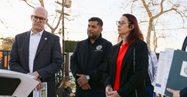Hugo Soto-Martinez stands at a press conference with his hand folded in front of him.