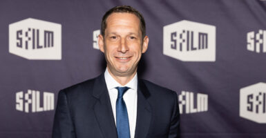 Daniel Lurie looks straight ahead and smiles as he poses for a photo at a film festival.