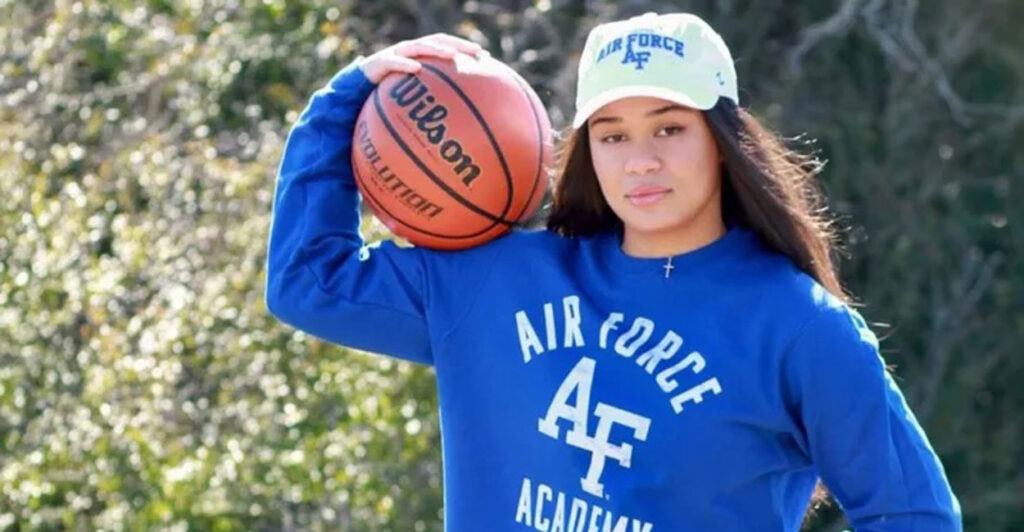 18-year-old Ava Moore in a blue Air Force sweatshirt, holding a basketball.