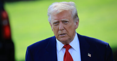 Donald Trump in a blue suit with an American flag pin