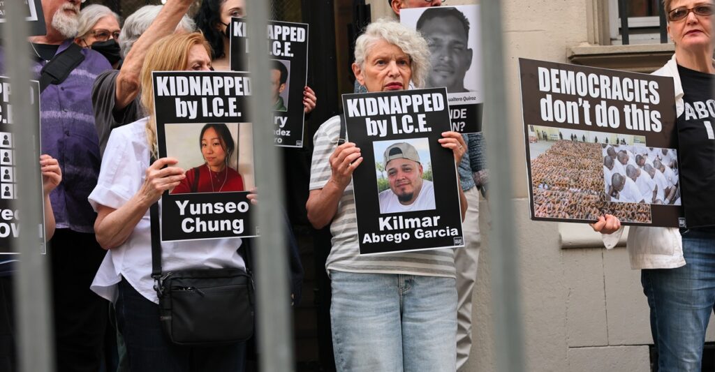 Protesters line the street holding up posters in support of Kilmar Abrego Garcia.