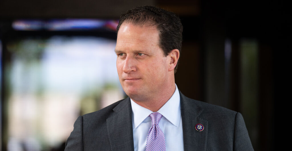 Rep. August Pfluger in dark jacket and lavender tie, looking to his right.
