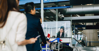 Three airport passengers lining up to show ID.