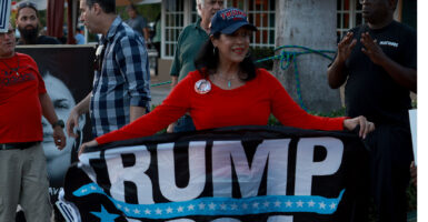 People in Miami, Florida, display photographs of political prisoners being held in Cuban jails during a March 18, 2024, demonstration in support of the Cubans, while also indicating their support for President Donald Trump's reelection.