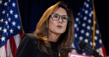 House Republican Conference Chairwoman Lisa McClain, R-Mich., with two U.S. flags as backdrop