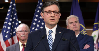 Speaker of the House Rep. Mike Johnson, R-La., speaks as Rep. John Rutherford, R-Fla. (left), and House Majority Whip Rep. Tom Emmer, R-Minn., look on at a news conference at the Capitol on Wednesday.