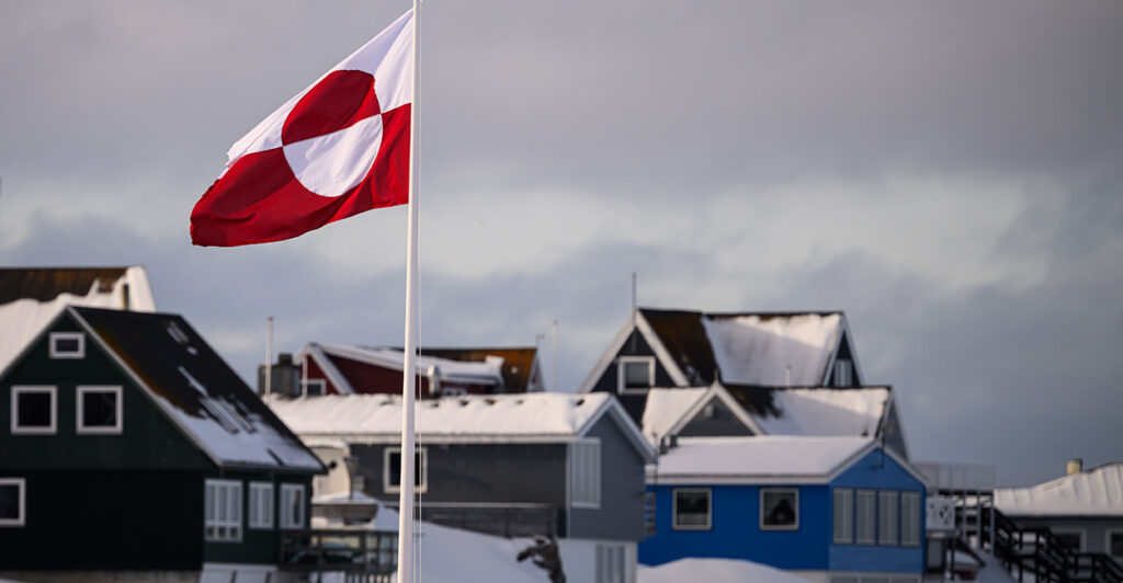 The Greenland flag flies near homes in Nuuk, the North Atlantic island nation's capital, on March 28.