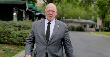 Border czar Tom Homan walks towards reporters in a gray suite outside the White House.