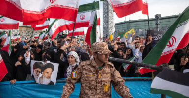 Iranians wave the country's flags during a ceremony commemorating the anniversary of the death of Iranian President Ebrahim Raisi on May 15 in Tehran, Iran.