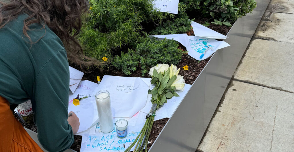 Anna Beth Havenar writes a message on a piece of paper at a small memorial honoring slaying victims Yaron Lischinsky and Sarah Milgrim outside the Jewish Museum in Washington on Thursday.