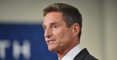 Lockheed Martin CEO Jim Taiclet in a suit with a blue and tan background