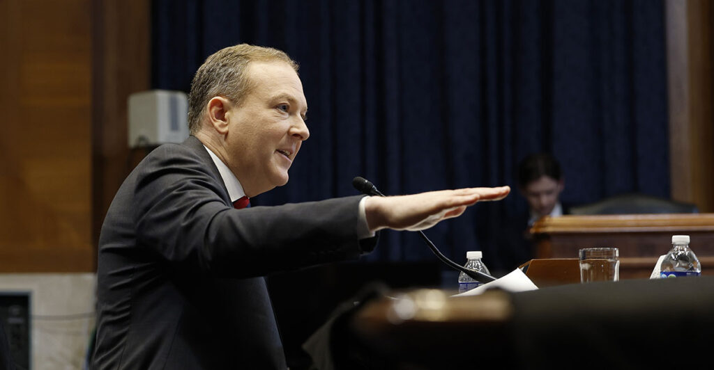 Lee Zeldin in a suit gestures with his hand