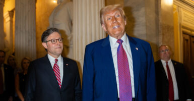 With Speaker of the House Mike Johnson, R-La., looking on, President Donald Trump speaks to reporters Tuesday at the Capitol after a House Republican Conference meeting.