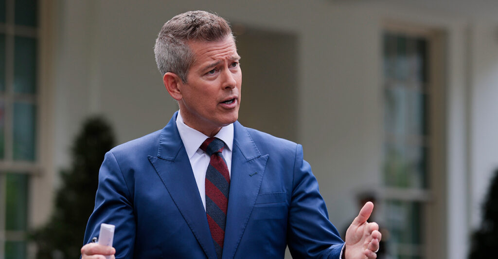 Transportation Secretary Sean Duffy in blue suit and hands spread speaks outside the White House.