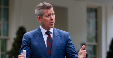 Transportation Secretary Sean Duffy in blue suit and hands spread speaks outside the White House.