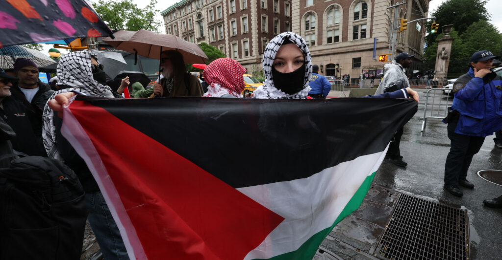 A demonstrator holds up a Palestinian National flag as Columbia University and Barnard College students hold a graduation rally in support of Palestine in New York on May 21, 2025.