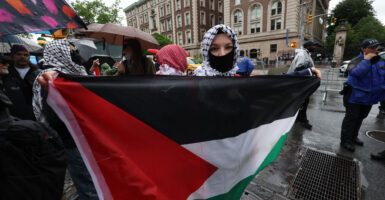 A demonstrator holds up a Palestinian National flag as Columbia University and Barnard College students hold a graduation rally in support of Palestine in New York on May 21, 2025.