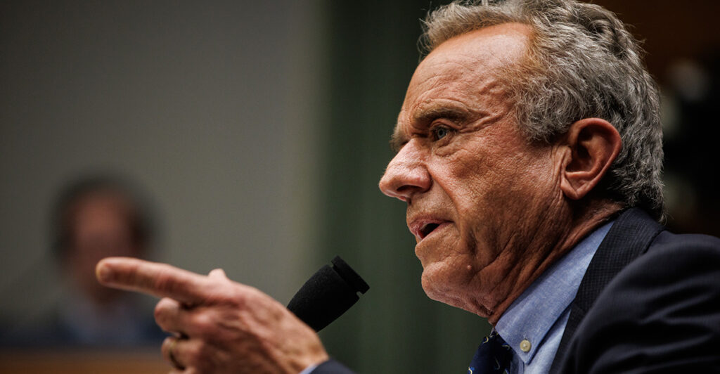 HHS Secretary Robert F. Kennedy in profile pointing during a Senate hearing.