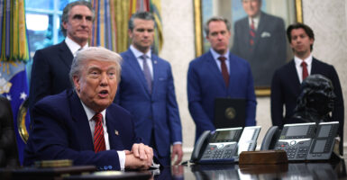 With other administration officials looking on, President Donald Trump speaks after signing executive orders in the Oval Office on Friday.