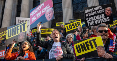 anti-Donald Trump protesters holding up signs such as unfit, loser, and criminal