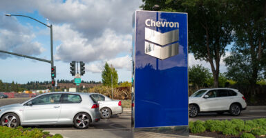Chevron sign outside their corporate headquarters, with cars passing by in the background.
