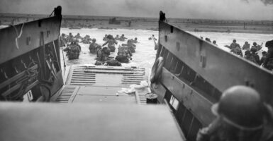 View from a transport of start of D-Day invasion, with troops in the water and Omaha Beach in the background.