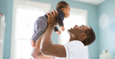 A doting dad holds his baby son aloft