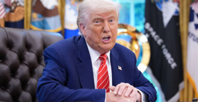 President Trump speaks while seated at his desk in the Oval Office.