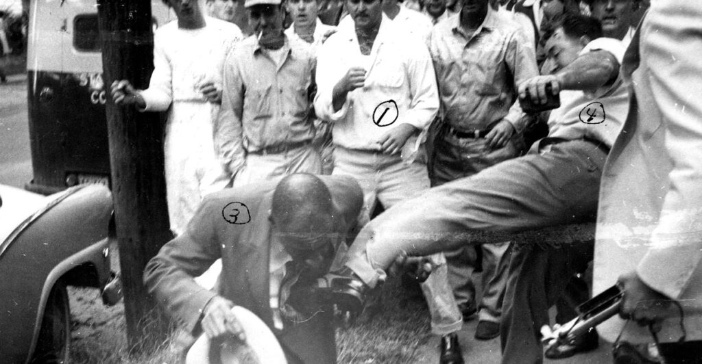 An anti-desegregation protester kicks Alex Wilson, a black man, in the chest outside Little Rock Central High School on September 23, 1957.