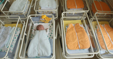 Overhead shot of a hospital nursery, empty but for one baby.