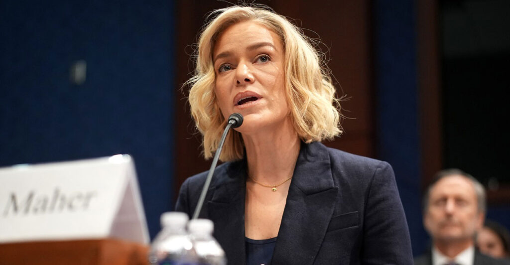 Katherine Maher sits and tilts her head to the left as she speaks into a microphone.