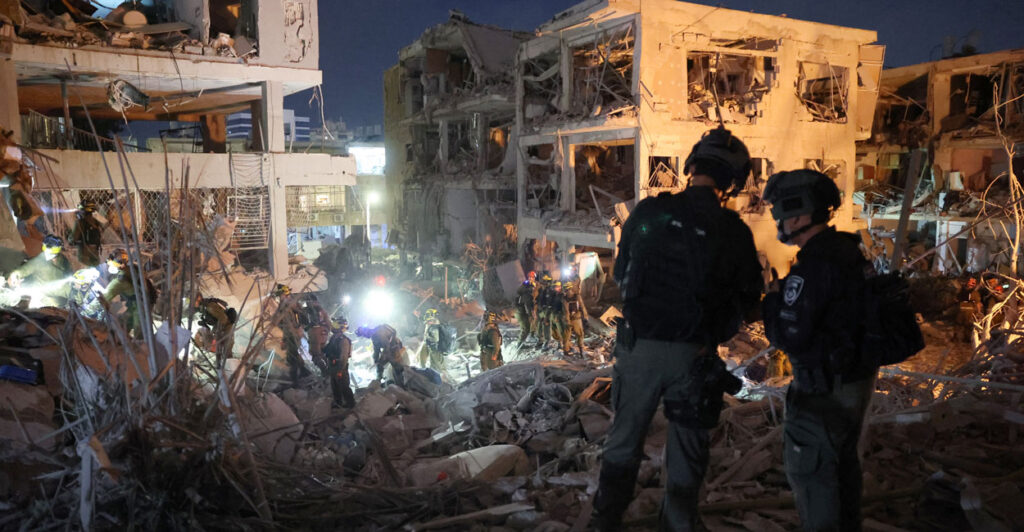 Responders search through building rubble following a strike by an Iranian missile in the Israeli city of Bat Yam near Tel Aviv.