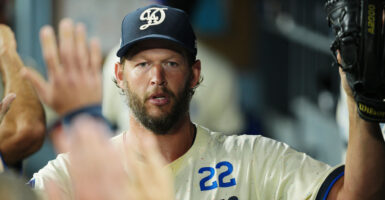 Dodger pitcher Clayton Kershaw gives high-fives in the dugout.