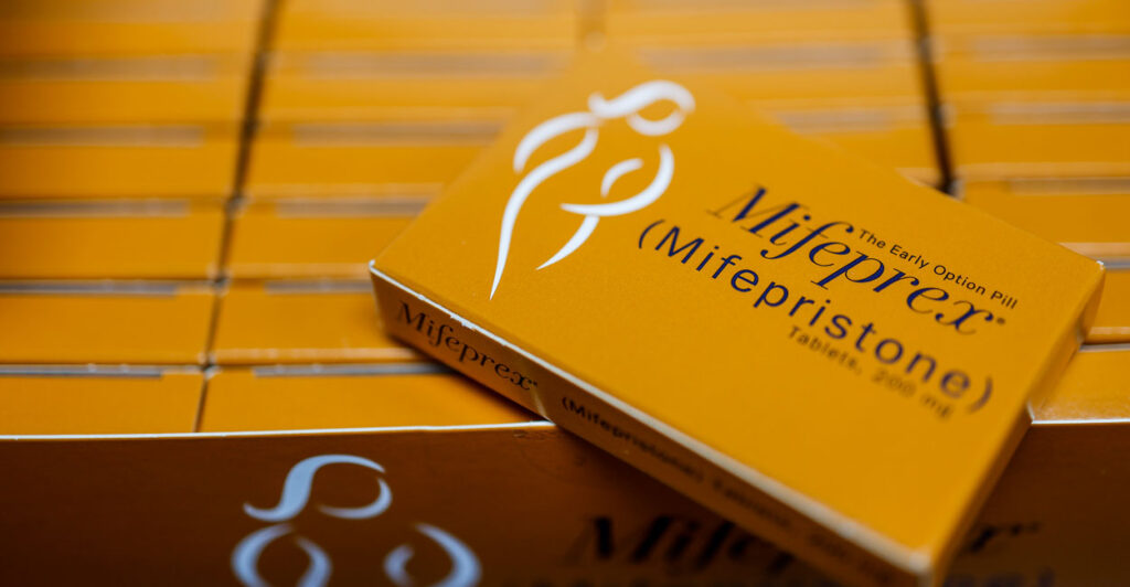 Numerous orange boxes of Mifepristone.